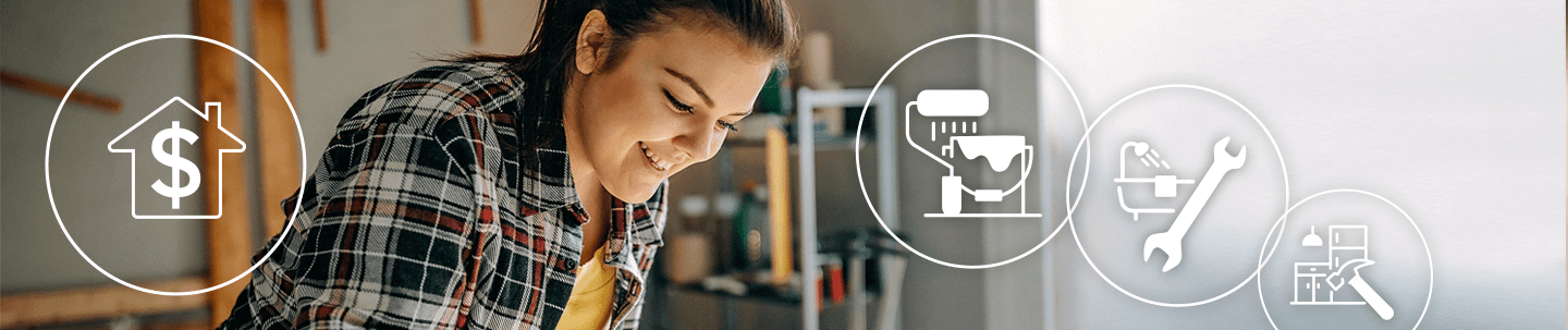 Smiling young woman applying white paint to wooden planks with a paint brush